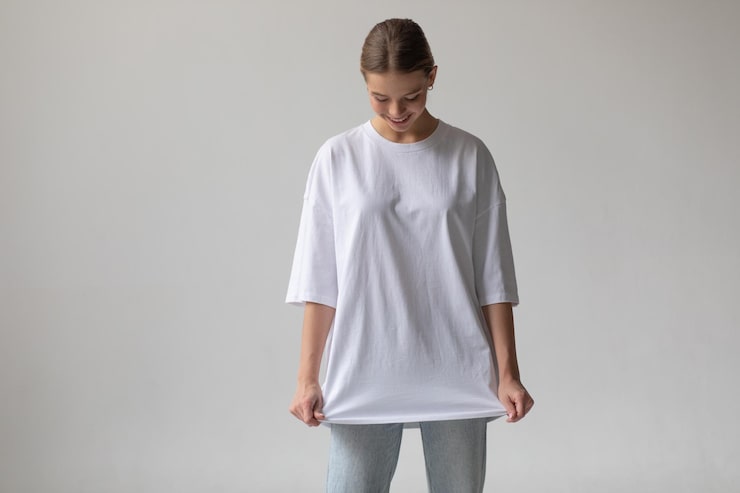 bella chica rubia camiseta blanca gran tamano vaqueros azules posando sobre fondo gris 89887 902